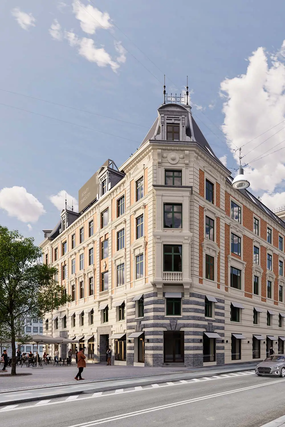 Historisches Eckgebäude mit Stuckfassade, roten Ziegelbändern und Granitsockel, davor Cafébestuhlung